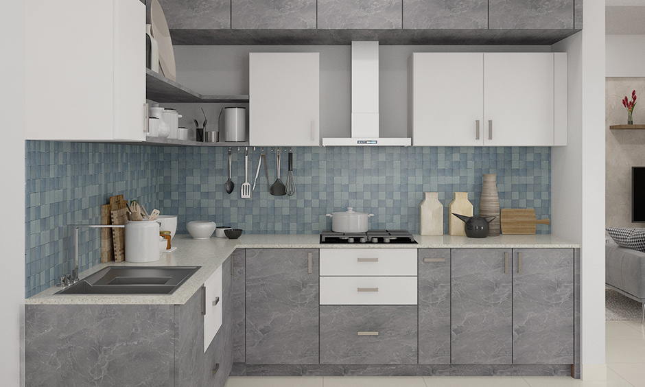 Blue chequered backsplash kitchen wardrobe design with a combination of grey marble finish & white laminate looks soothing