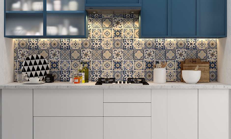 Single wall kitchen in bold blue and white with a pretty floral tiled backsplash and cabinets look gorgeous.