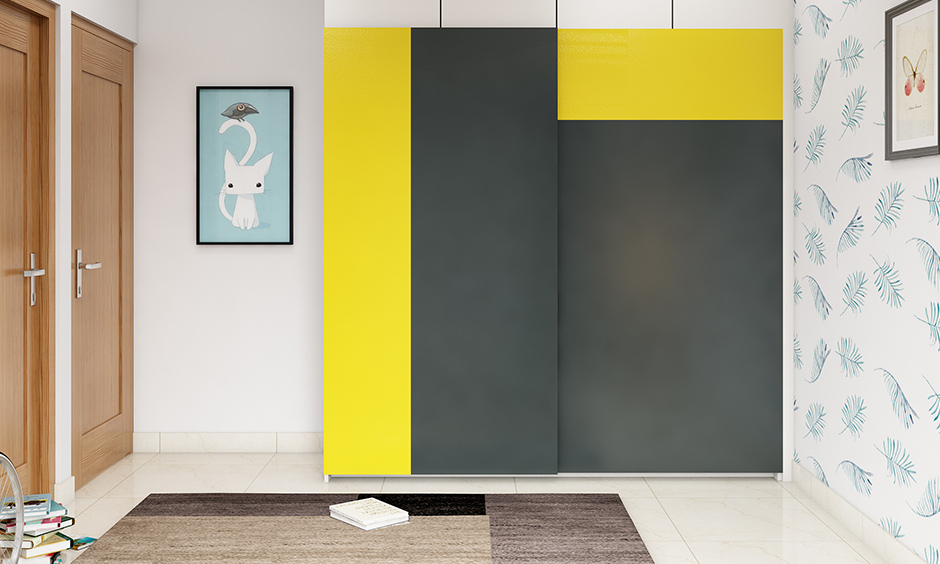 The bedroom has a bright yellow and grey double colour wardrobe design.