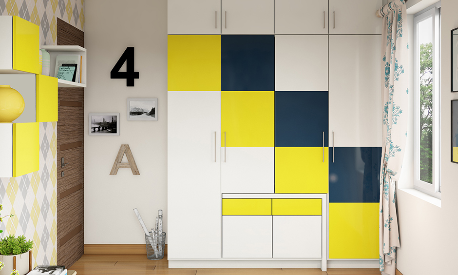 White coloured wardrobe with fun squares of dark teal and yellow laminates colour combination for wardrobe design.