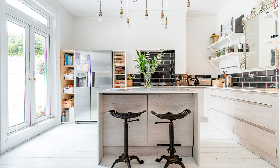 Kitchen island with open shelves made from beach wood gives this open kitchen a rustic vibe & drop down rope lights.