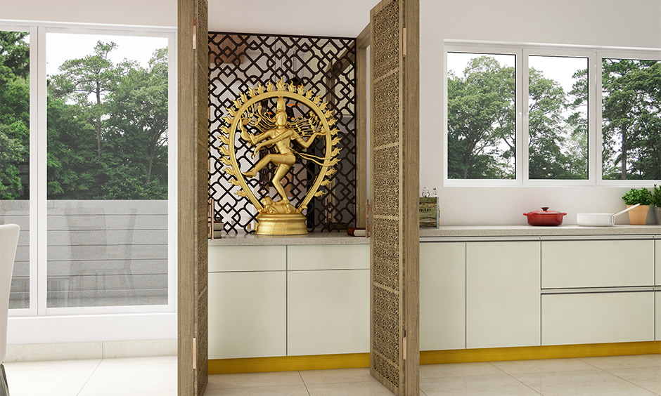 Pooja room in kitchen as per vastu comes with a tall unit and jali doors made from wood