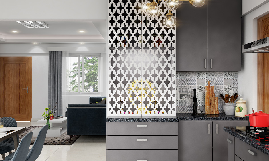 Pooja room in kitchen comes with a criss-cross pattern door made from white wood