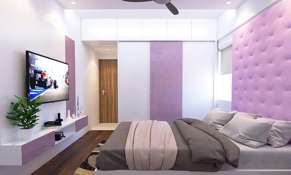 Glossy finish white and lilac wardrobe colour combination in this bedroom works well.