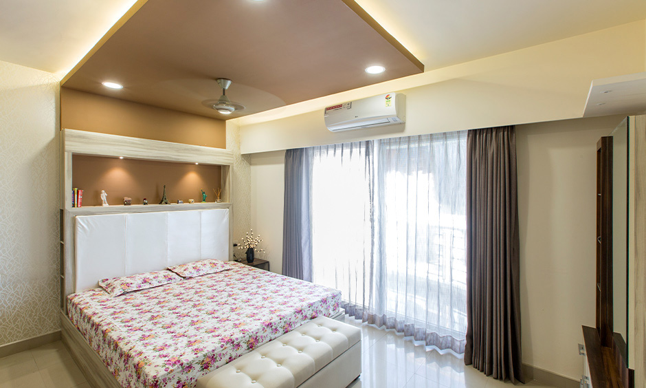 A bedroom features earthy false ceiling colour