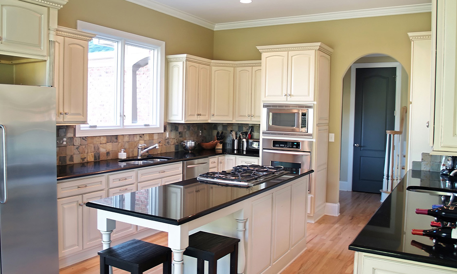 Classic island kitchen with absolute black granite countertops and white cabinets looks pretty and sleek.