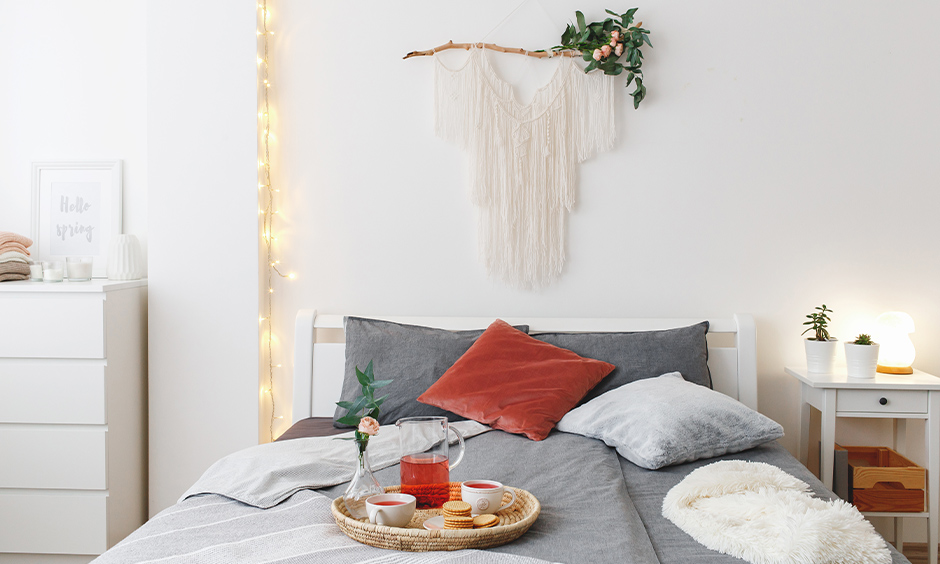 White bedroom with a piece of wall art and fairy lights in vertical look elegant is the best fairy lights for bedroom.