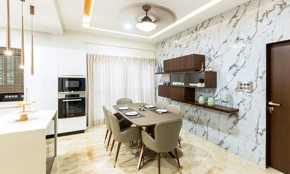 The dining cum kitchen area with dining table & wall-mounted crockery unit designed by best interior firms in Bangalore.
