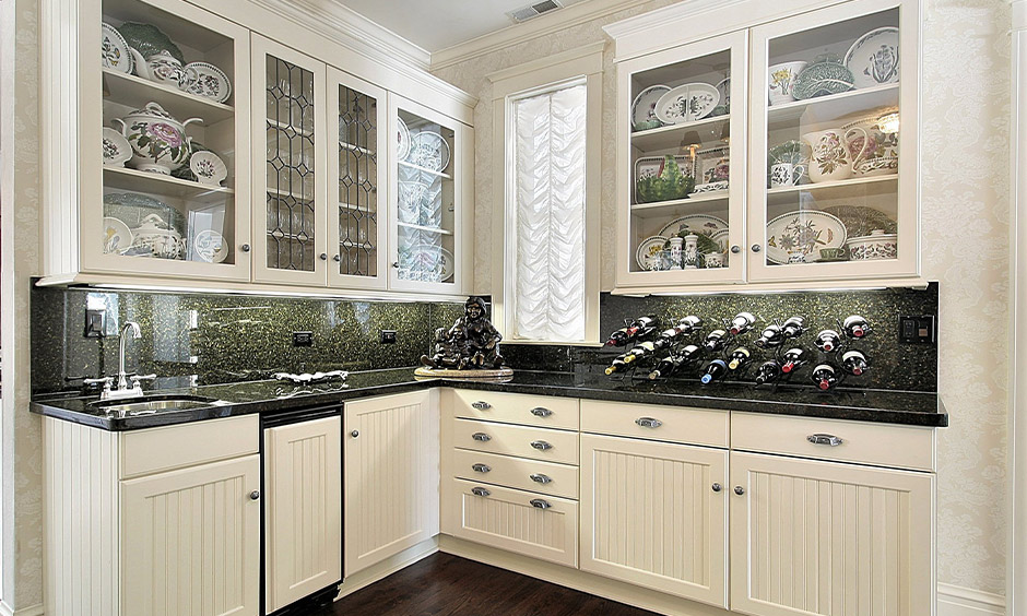 Transparent glass shutter kitchen accentuates the elegance and style of the white modular kitchen.