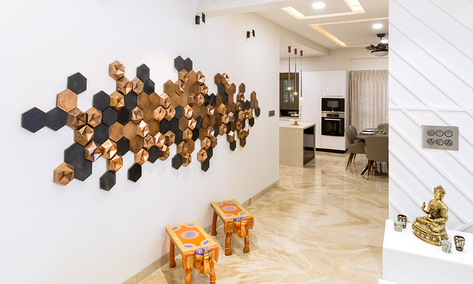 The foyer wall decor made with 3D tiles in black and rose gold designed by DC interior design firms in Jayanagar.