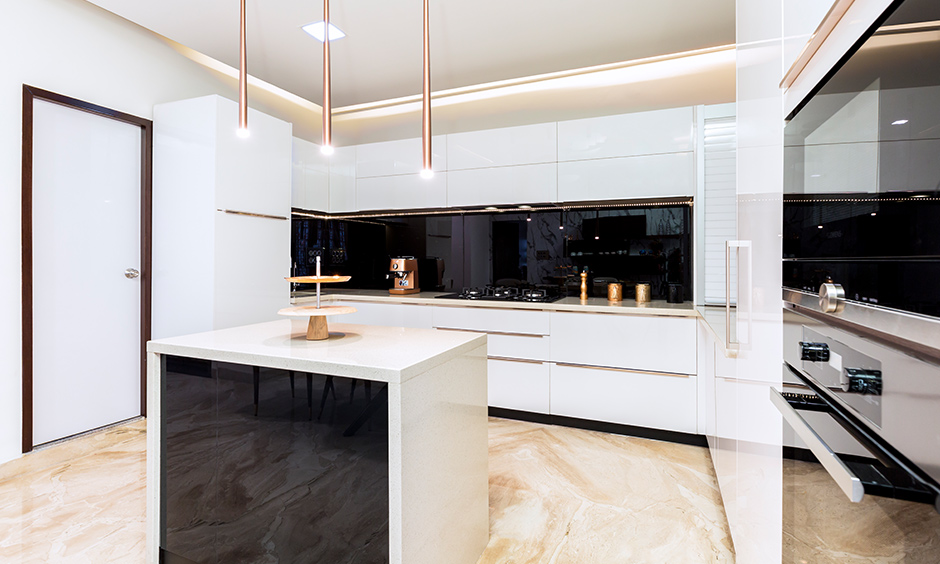 Best interior design firms in Bangalore designed this island kitchen in a white acrylic finish with cove light & LED lights.