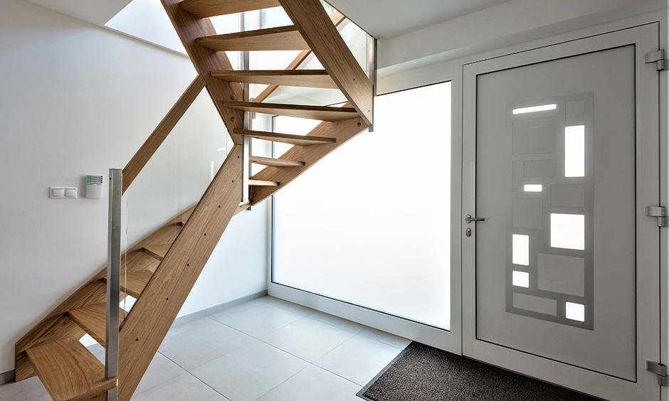 Wooden stair railing with glass and steel lend a modern yet mid-century vibe