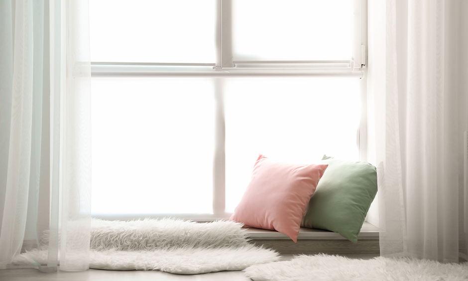 Floor seating idea for living room, Fur comforters and two bright coloured cushions seating adds a vibe to the area.