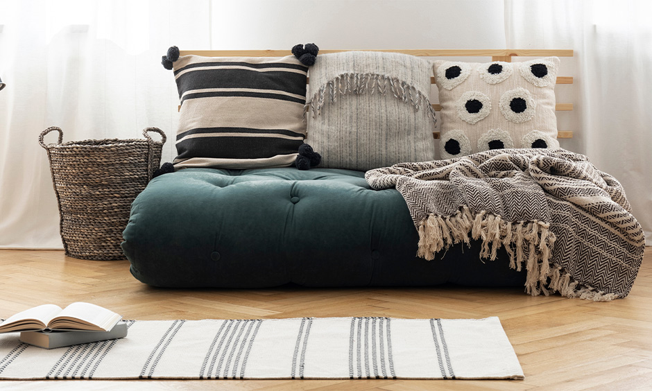 Patterned cushion paired with grey rugs elevates the area's look and comfort, floor cushion seating idea.