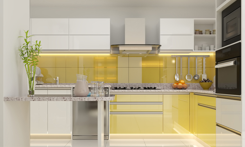 Grey and yellow kitchen with breakfast counter and cabinet lighting look classy.