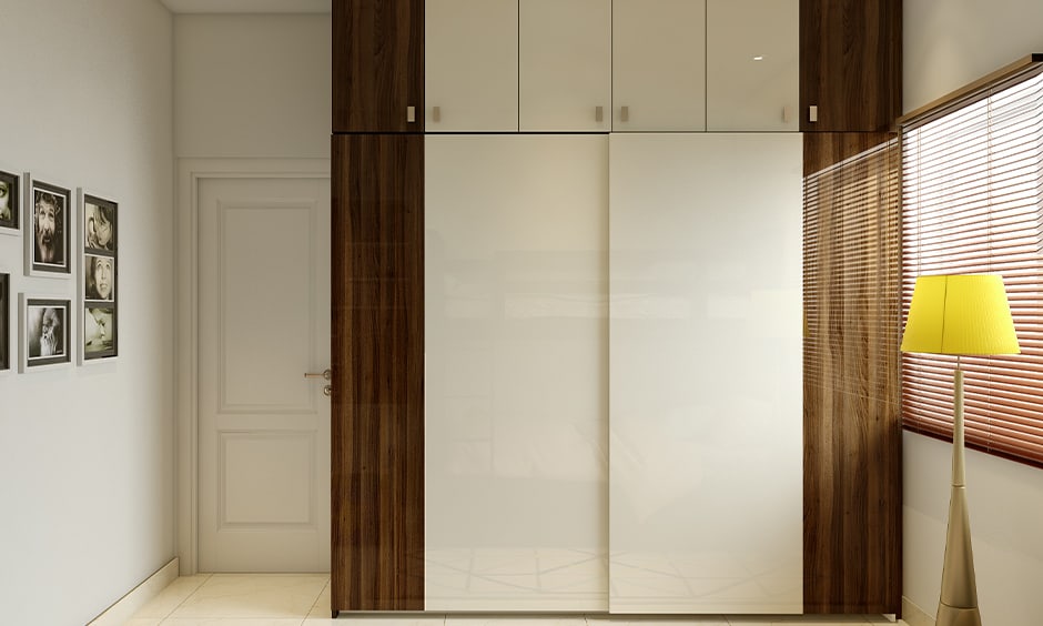 Simple white bedroom cupboard design in glossy finish gives a royal touch