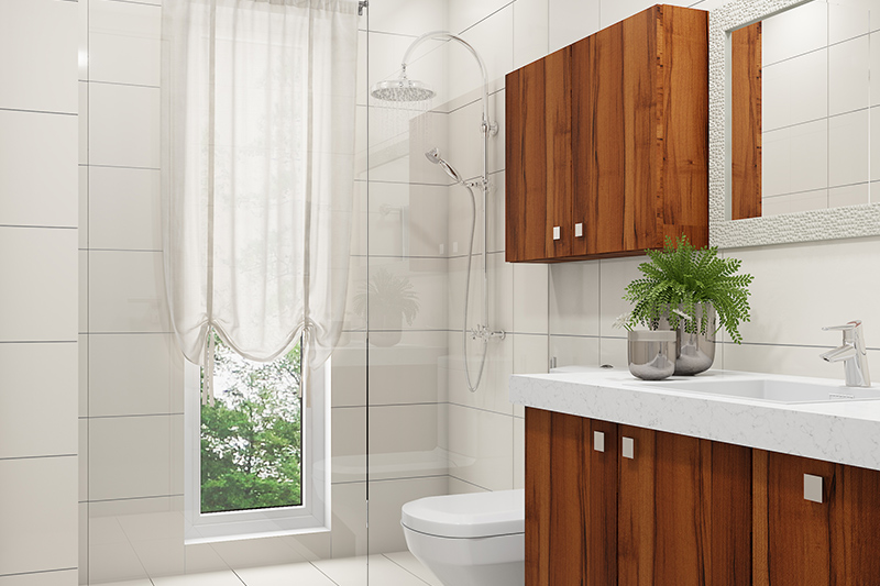 Bathroom renovation with white porcelain tiles, a thick-glass divider and wooden cabinets for a sleek look.