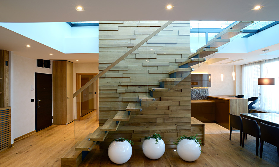 Lightwood contemporary staircase design with glass handrails enhances the existing interior design