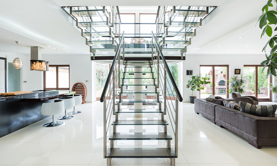 A split contemporary staircase with glass steps and stainless handrails lend the best eye-catching design