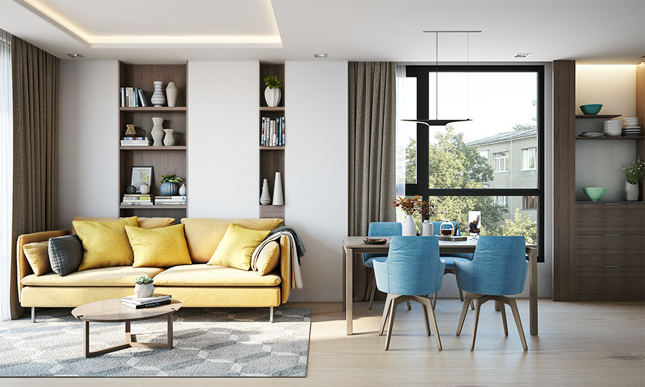 Blue dining chairs and yellow sofa in open living room cum dining area