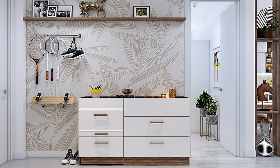 Room with white and brown wallpaper, sleek entryway table with minimalist design and drawers.