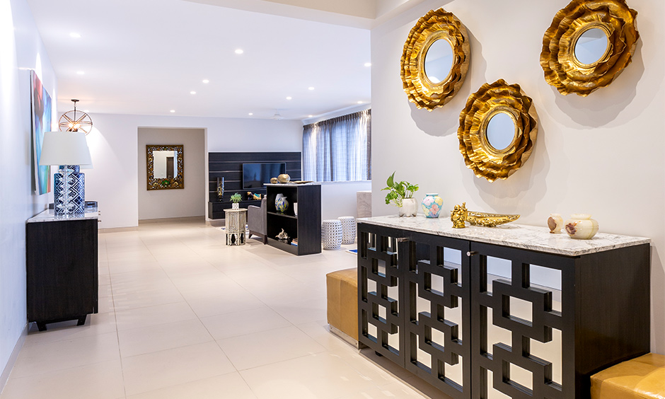 Black and white entryway table and the mirrors on the wall create a sophisticated ambience in the hallway