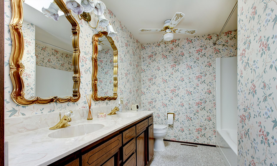 Shabby chic bathroom design with crafted cabinetry, decorated walls, and a gold-framed mirror
