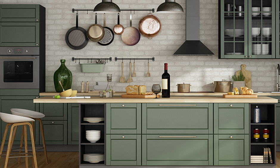 Sage green kitchen cabinets coupled with dark accents for an elegant look
