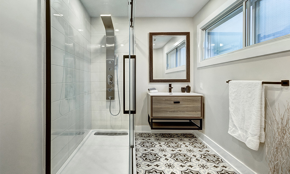Modern walk-in shower with beige ceramic tiles and glass doors