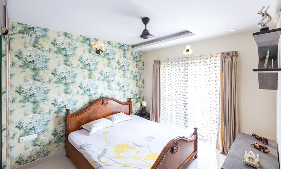 Rustic plywood Sunmica bed in a cosy bedroom with floral wallpaper wall
