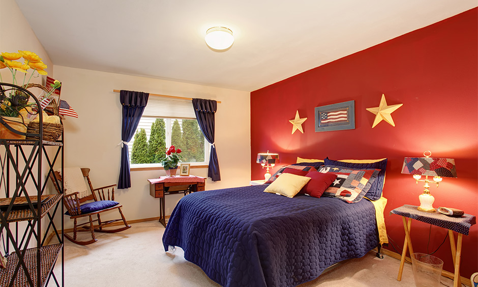 American-themed bedroom with red accent wall, blue bedding, and yellow decor - perfect red and blue colour combination