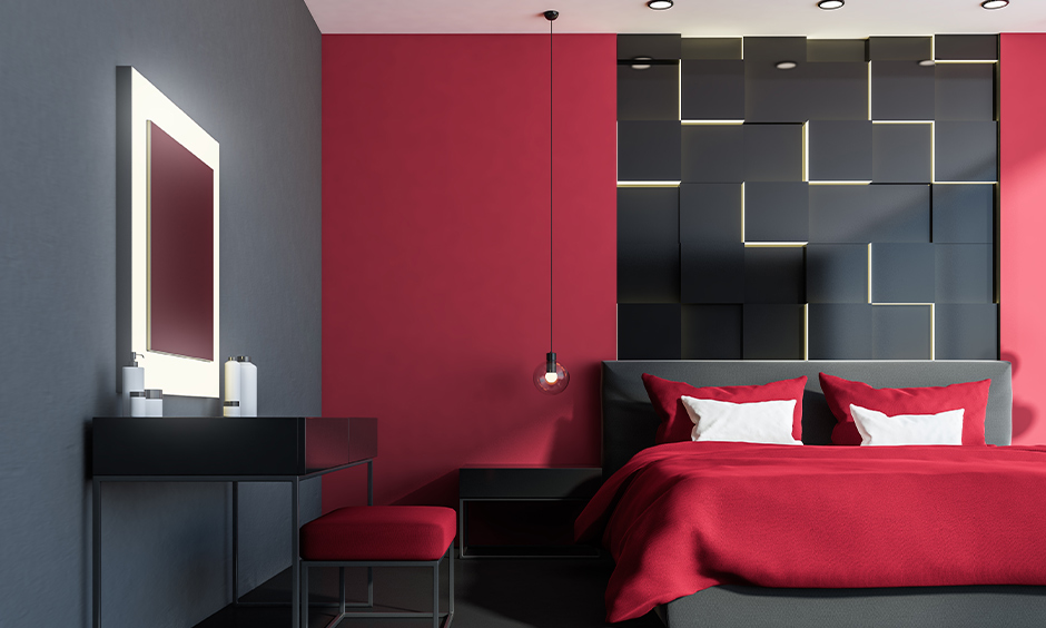 A red and grey colour combination in a modern bedroom includes a deep red wall, grey bedding, and a slate grey accent wall