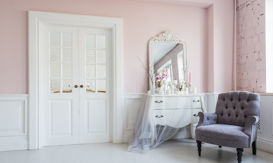 Classic white dressing table with ornate details, curved design, and mirror creating a vintage-inspired space