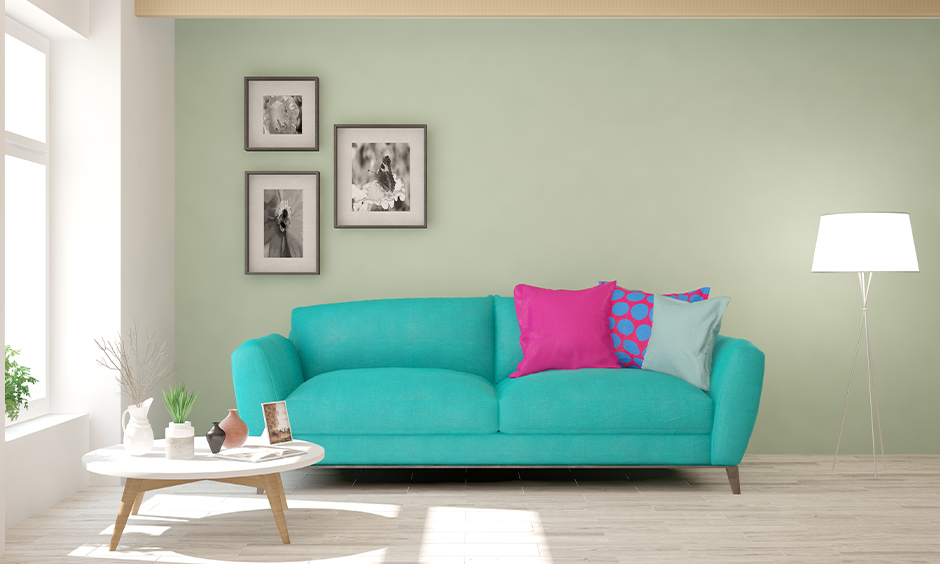 Pastel-colored living room with green walls, turquoise couch, and modern, fresh decor