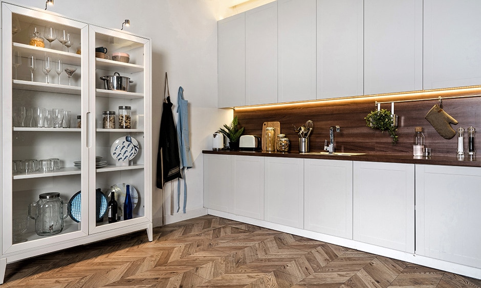 Woven bamboo flooring in herringbone pattern creates spacious, durable kitchen with white cabinets