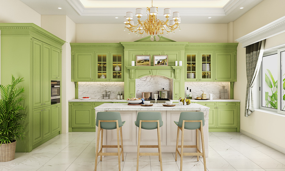 Pistachio green kitchen cabinets with marble countertops and gold accents reflect 2025's colour trends.