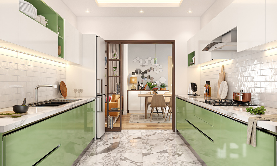 Light green kitchen cabinets with white accents, marble countertops, and tiled backsplash create a calming, modern space.