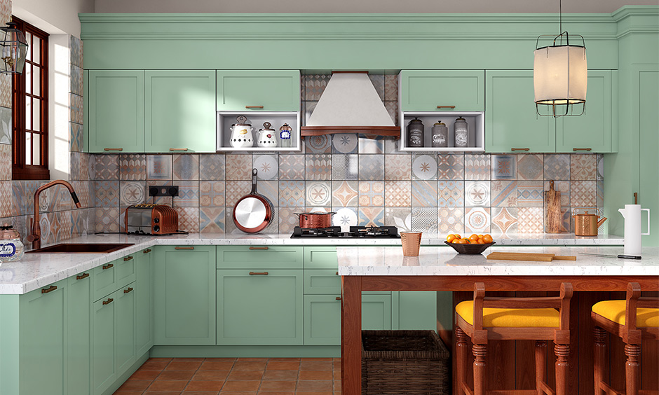 Modern kitchen with sage green cabinets, marble countertops, tile backsplash, and warm wood accents