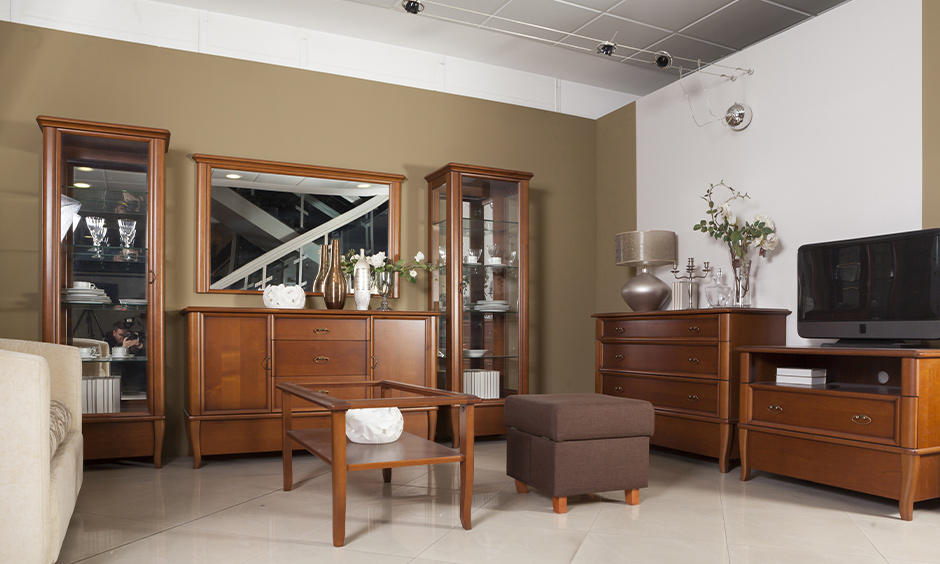 Wooden almirah with mirror, sideboard, and centre table adds old-school charm to a modern living room.