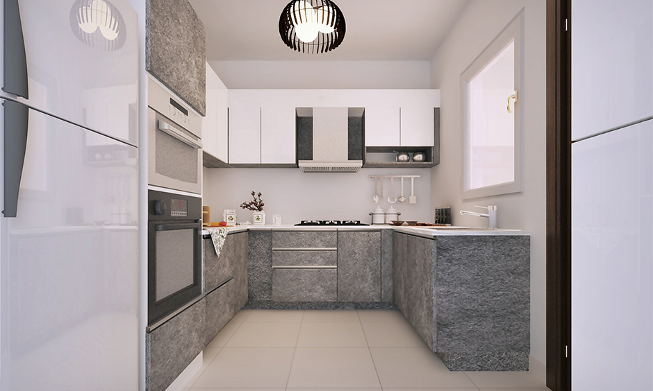 A modern small U-shaped kitchen with light grey and white design, open layout, and pendant light.