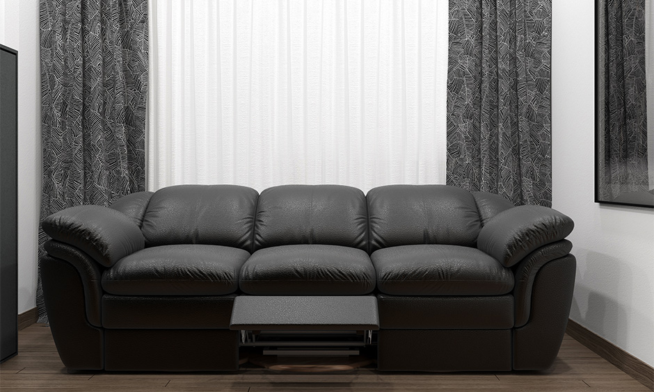 Plush dark grey three-seater recliner sofa, perfect for relaxation in a stylish living room.