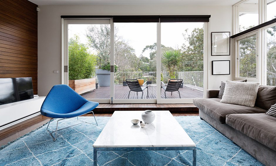 Triple-panel wooden sliding door in white, adding a spacious and airy feel to the living room