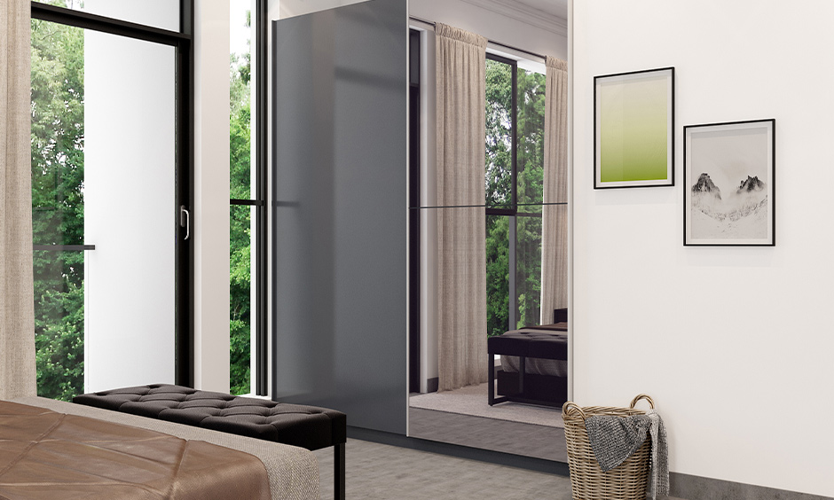 A black wardrobe with sliding doors and a mirror creates a bold, dramatic look, enhancing modern interior spaces.