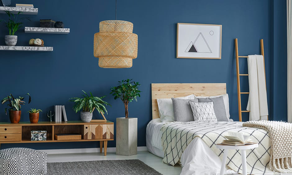 Light grey and peacock blue bedroom with wooden elements and green plants