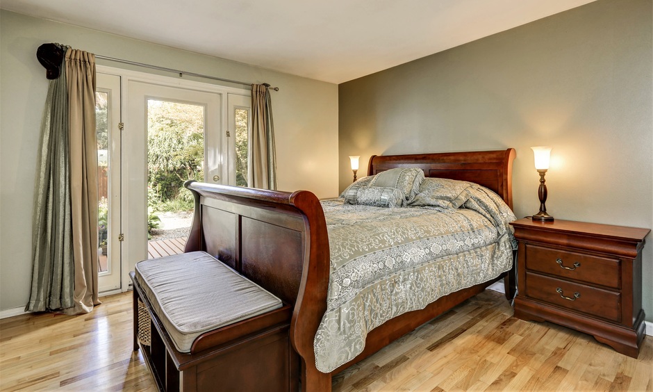 Luxury solid wood bedroom furniture features a classic bed, a polished nightstand, and a stylish wooden bench.