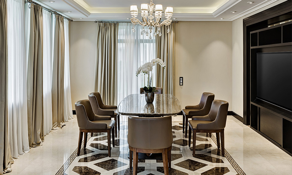 Oval-shaped glass dining table design with a granite base adds sophistication to the dining room.