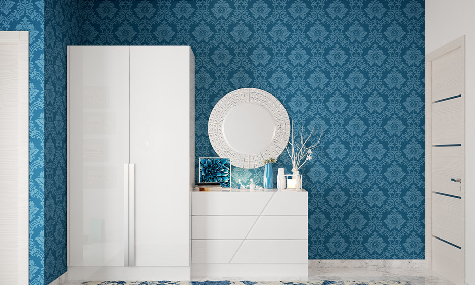 Peacock blue and white bedroom with a wall mirror and glossy wardrobe finish
