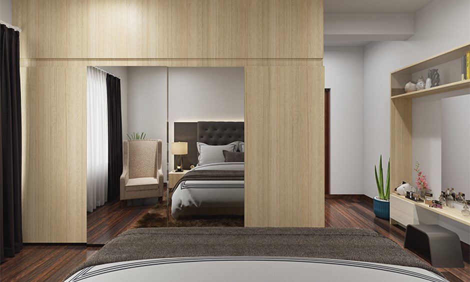 A sliding door almirah with mirrors in sunmica offers easy maintenance and a clean look for the bedroom.