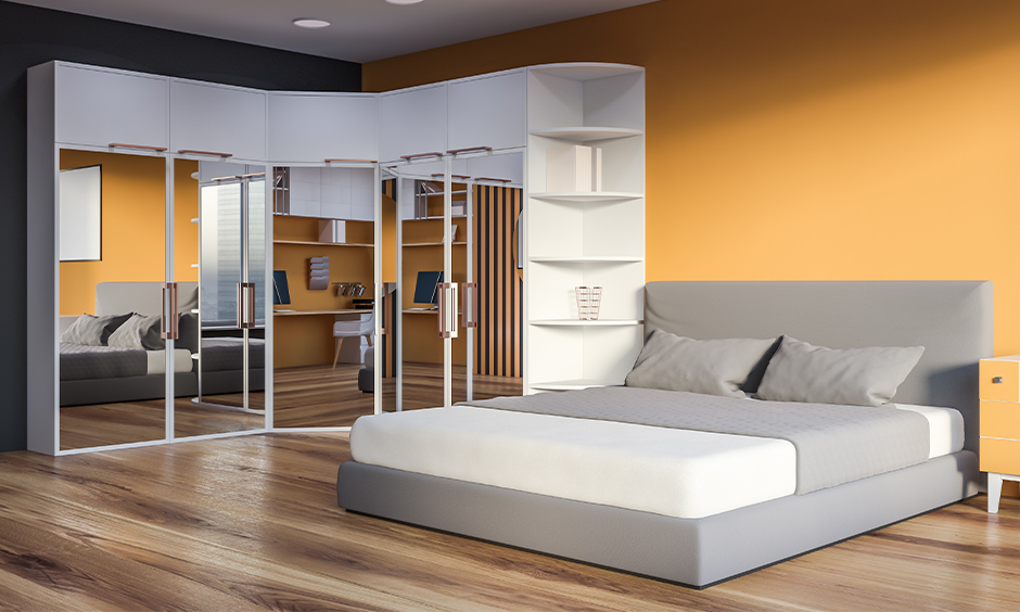 Wardrobe design with mirrored doors reflects wooden flooring and includes corner shelves for essentials.