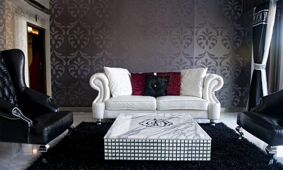 A lavish drawing room interior with an elegant coffee table, books, flowers, and stylish decor.